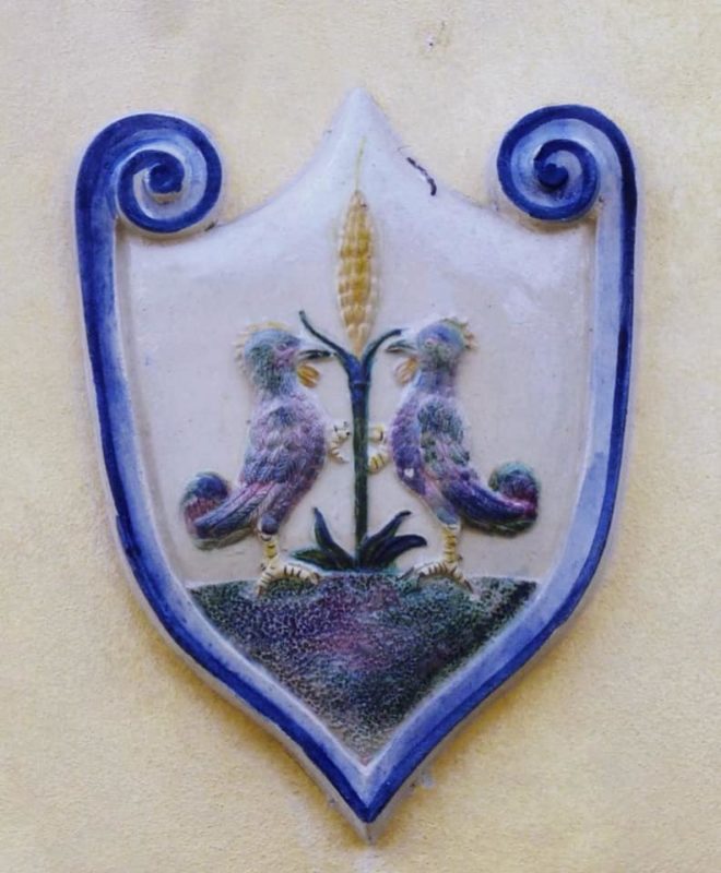 Ein Keramik-Wappen der Familie Cantagalli mit einer Ähre und zwei Hähnen.