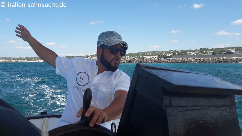Der Kapitän Davide de Giorgi am Steuer seiner Maretta. Im Hintergrund das Meer und die Küste von Torre Vado.